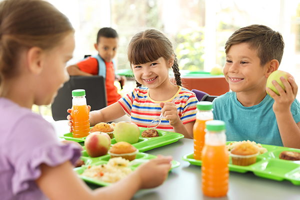 Elementary children eating lunch and smiling