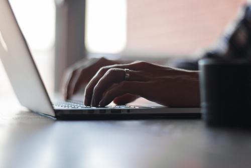 Person typing on a laptop keyboard