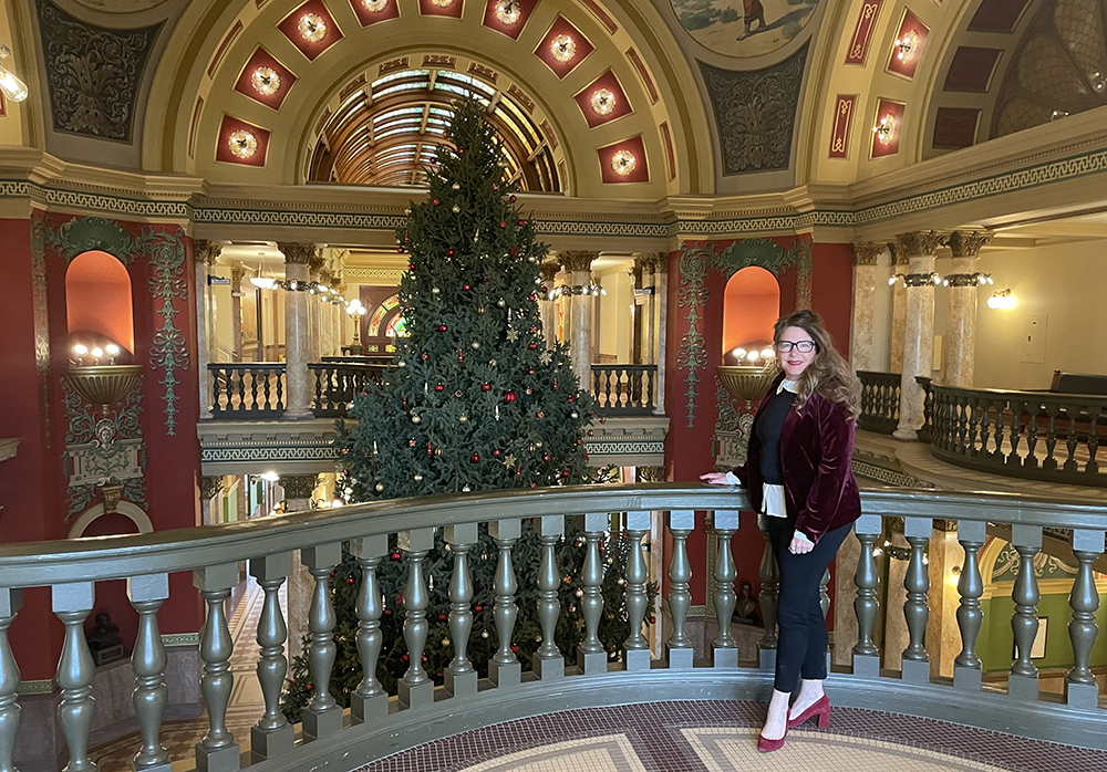 Superintendent Arntzen posing in front of the MT State Capitol Christmas tree.